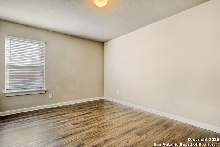 10583 Penelope Way Converse, TX 78109 - Photo 22 of 26 a view of an empty room with wooden floor and a window