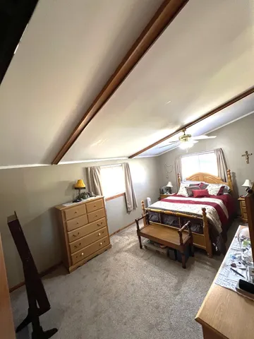 a bedroom with bed and a chair