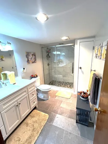a bathroom with a granite countertop sink a toilet and a shower