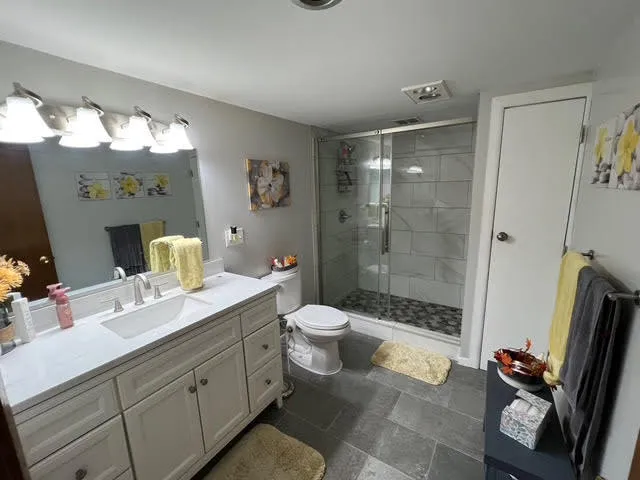a spacious bathroom with a double vanity sink toilet and shower