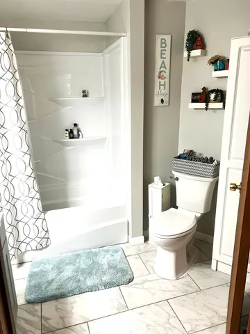 a bathroom with a toilet and a shower