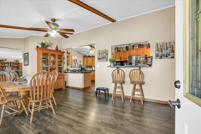 a kitchen with stainless steel appliances granite countertop a refrigerator a oven and a sink with wooden floor