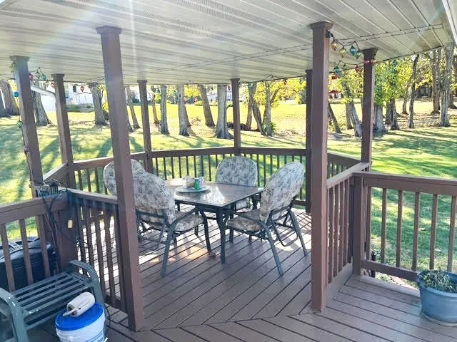a view of a patio with a table chairs and wooden floor
