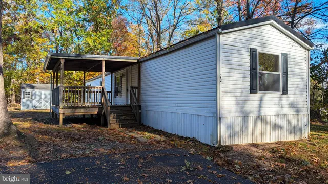 a backyard of a house with barbeque oven and trees