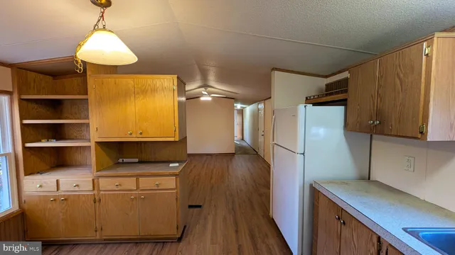 a kitchen with cabinets a refrigerator and a stove top oven