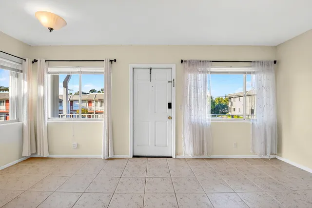 an empty room with closet and windows