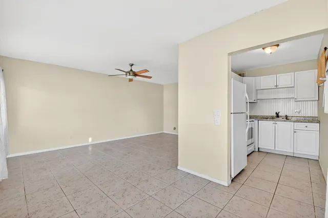 a view of a kitchen with white cabinets and white appliances