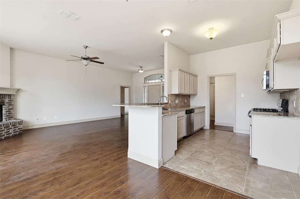 2512 Guinn Farms Road Tyler, TX 75707 - Photo 21 of 29 a kitchen with granite countertop a sink cabinets and wooden floor
