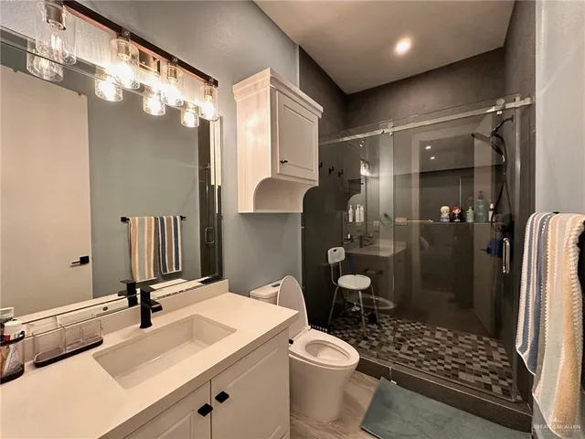 a bathroom with a sink a toilet and shower
