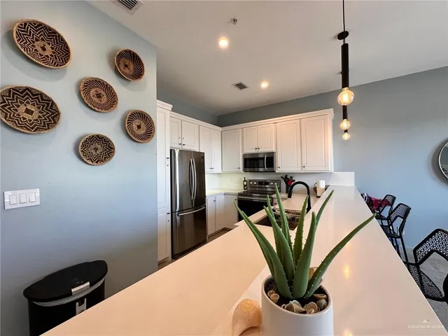 a kitchen with a refrigerator a stove and a wooden floor