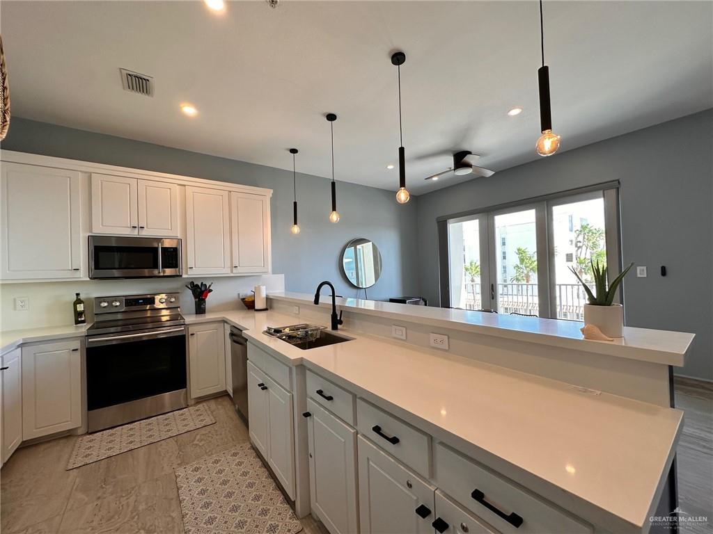 2700 Gulf Boulevard, Unit 204 South Padre Island, TX 78597 - Photo 10 of 31 a kitchen with stainless steel appliances granite countertop a sink a stove and a refrigerator