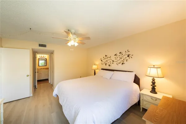 a bedroom with a large bed and a chandelier