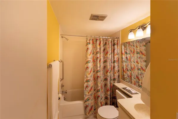 a bathroom with a toilet and shower curtain