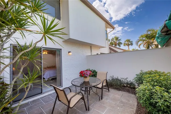 a view of backyard with a table and chairs and potted plants