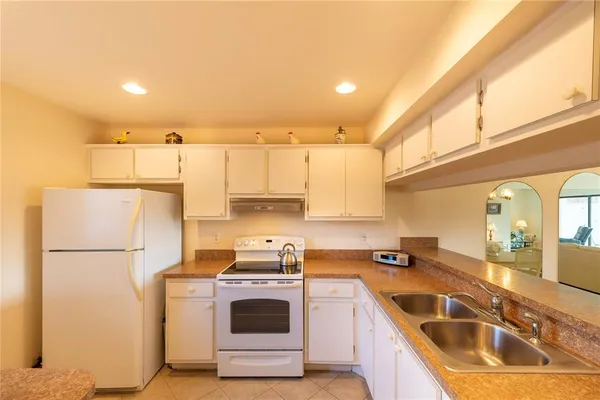a kitchen with a refrigerator sink and white cabinets