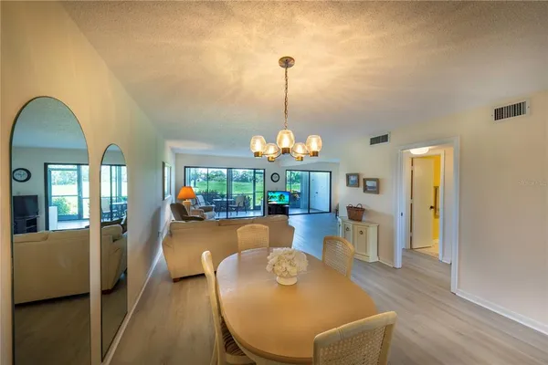 a view of a dining room with furniture wooden floor and chandelier