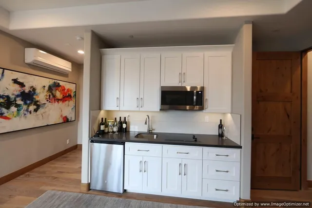 a kitchen with stainless steel appliances granite countertop white cabinets and sink