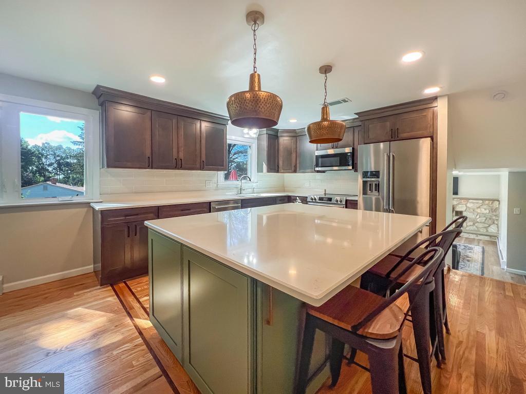 4643 Lerch Road Bensalem, PA 19020 - Photo 60 of 69 a kitchen with stainless steel appliances granite countertop a kitchen island a stove a dining table and chairs with wooden floor