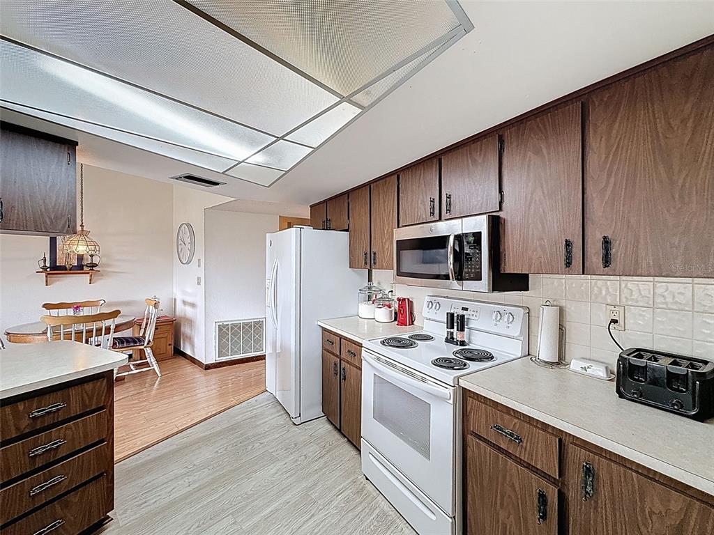 9030 Hernando Way Weeki Wachee, FL 34613 - Photo 19 of 67 a kitchen with stainless steel appliances a stove top oven a sink dishwasher a refrigerator and cabinets with wooden floor