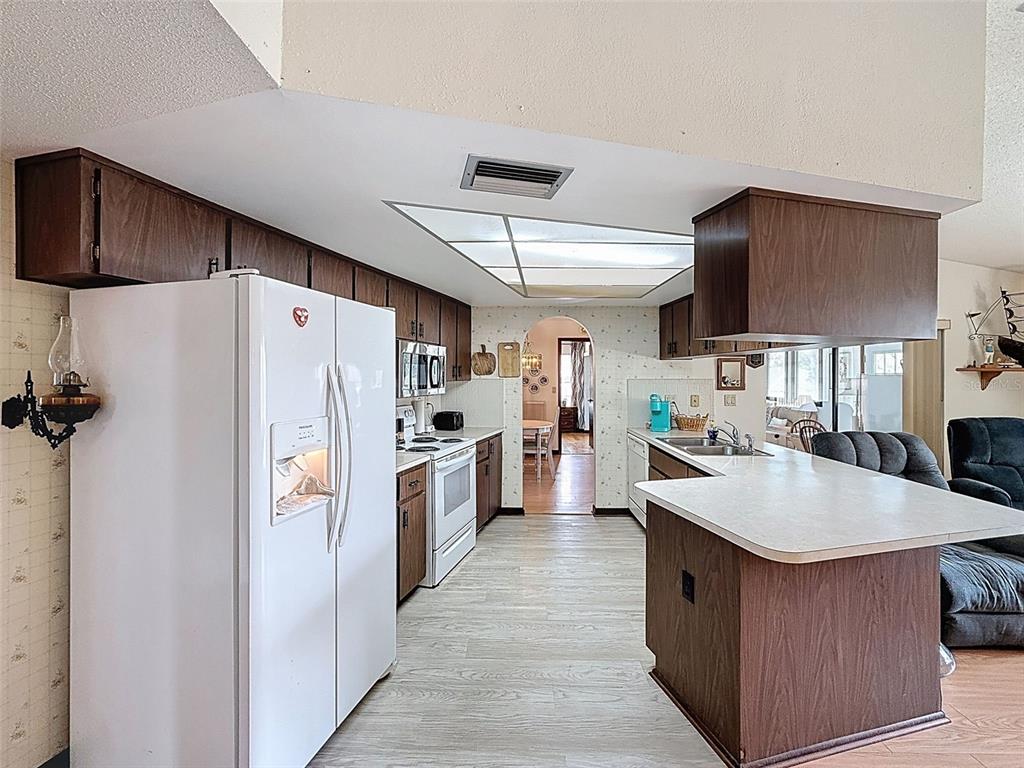 9030 Hernando Way Weeki Wachee, FL 34613 - Photo 22 of 67 a kitchen with refrigerator and cabinets