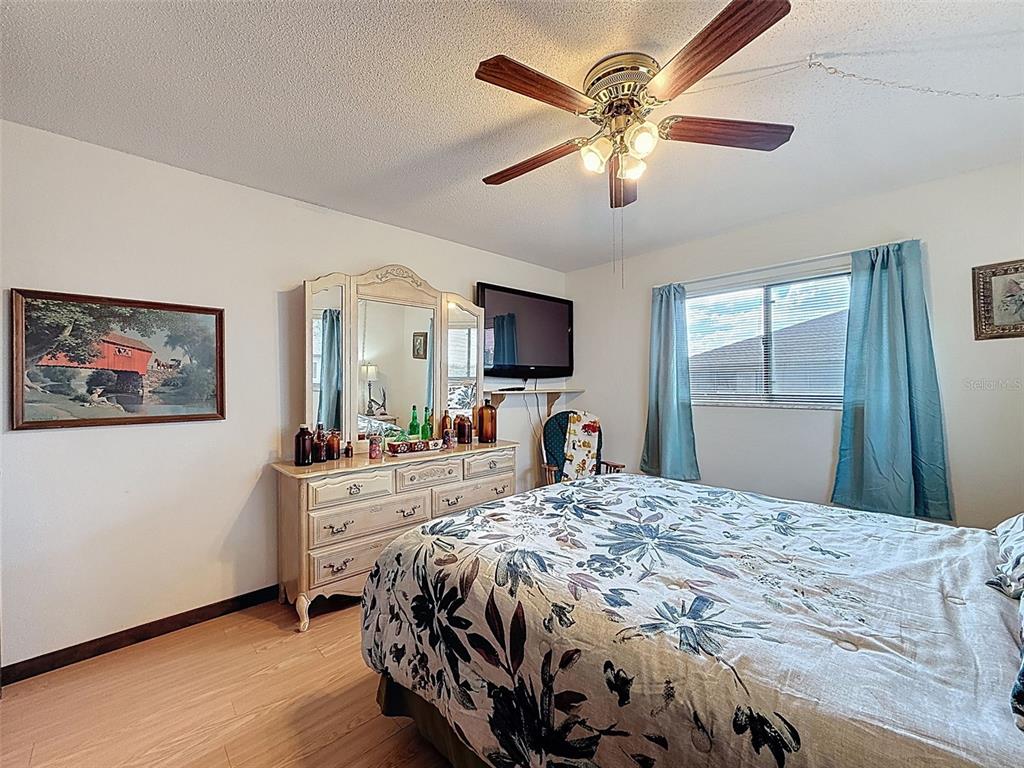 9030 Hernando Way Weeki Wachee, FL 34613 - Photo 43 of 67 a bedroom with a bed and a large mirror with wooden floor
