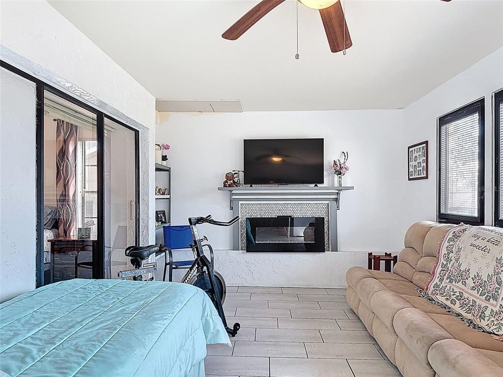 9030 Hernando Way Weeki Wachee, FL 34613 - Photo 55 of 67 a bedroom with a large bed and a fireplace