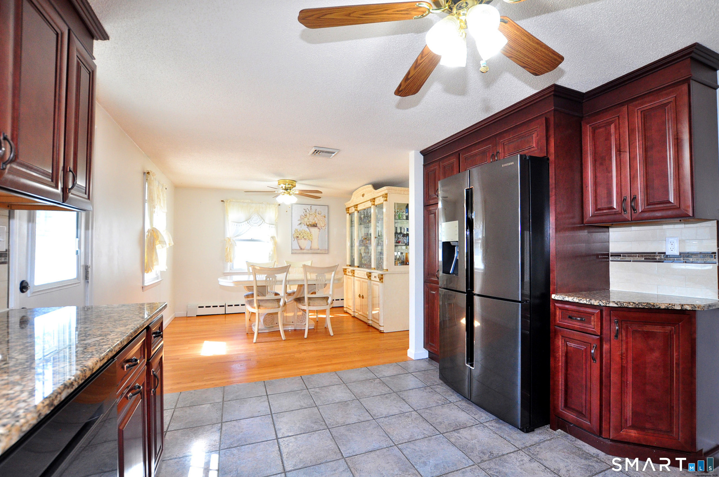 234 South Elm Street Windsor Locks, CT 06096 - Photo 9 of 33 a kitchen with stainless steel appliances granite countertop a refrigerator a sink dishwasher a dining table and chairs with wooden floor