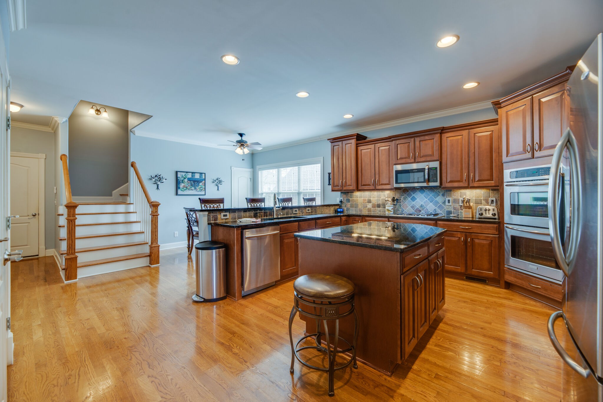 1215 White Rock Road Spring Hill, TN 37174 - Photo 12 of 42 a kitchen with stainless steel appliances granite countertop a refrigerator a sink dishwasher a stove and white cabinets with wooden floor