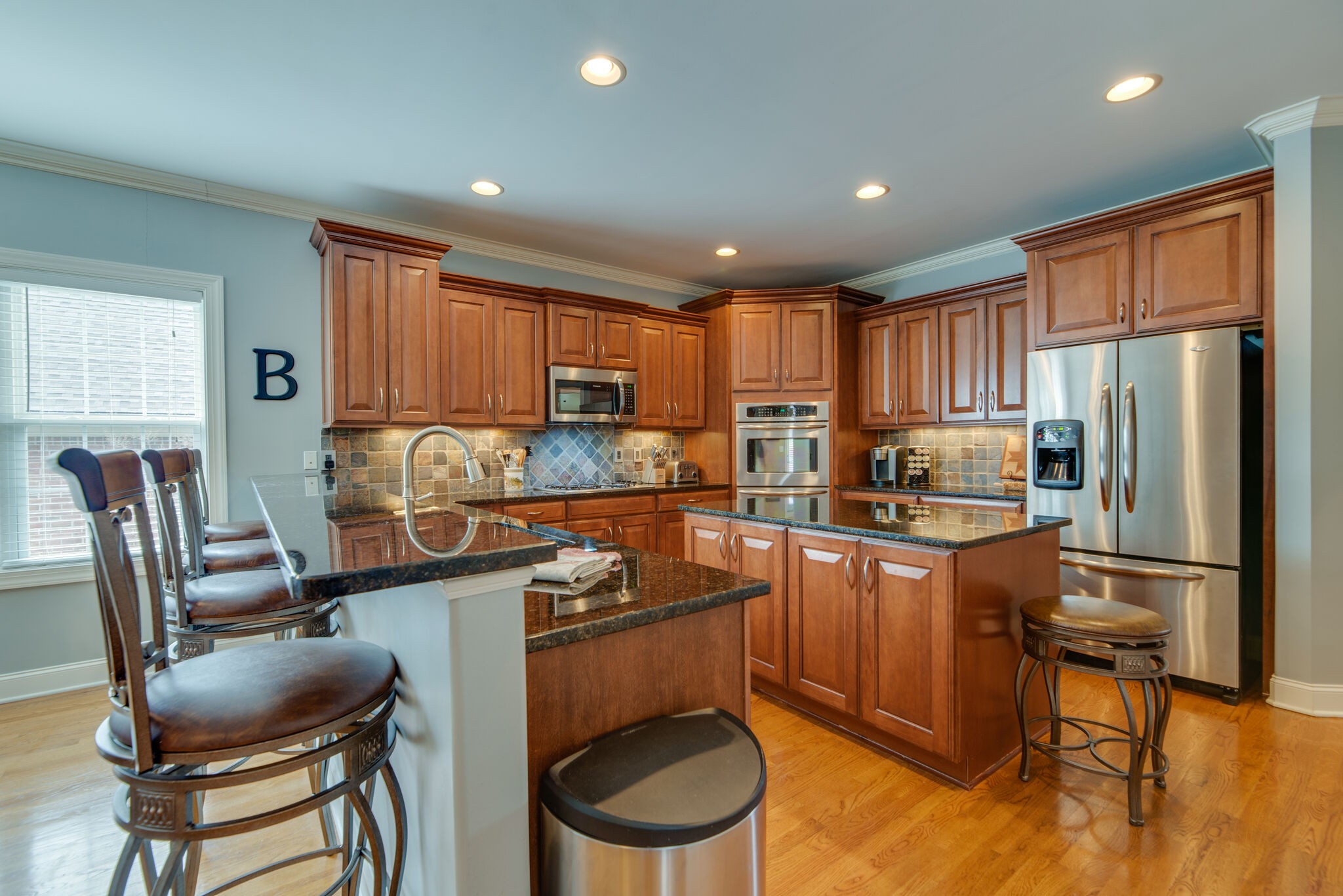 1215 White Rock Road Spring Hill, TN 37174 - Photo 13 of 42 a kitchen with stainless steel appliances granite countertop a refrigerator a stove a sink dishwasher a dining table and chairs with wooden floor