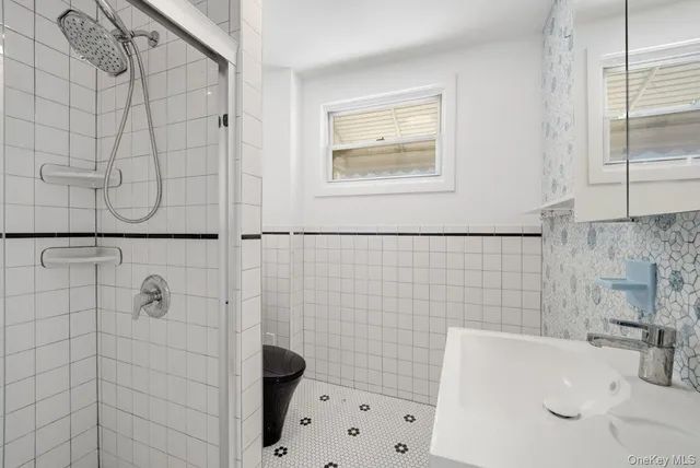 a bathroom with a sink a toilet and shower