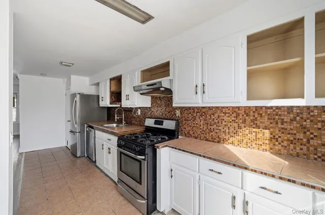 a kitchen with stainless steel appliances granite countertop a stove and a refrigerator