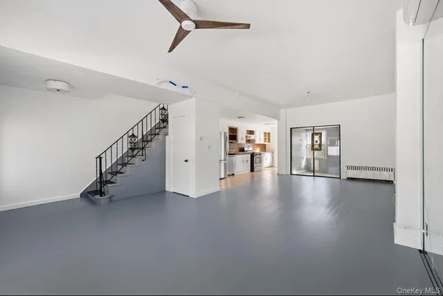 a view of a livingroom with wooden floor and stairs