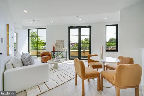 a living room with furniture and floor to ceiling windows