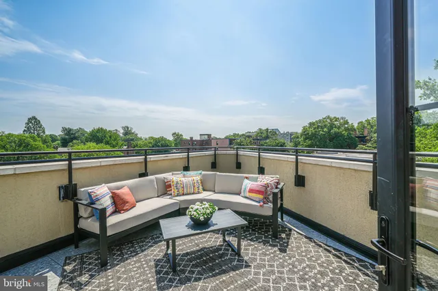 a balcony with furniture and a potted plant