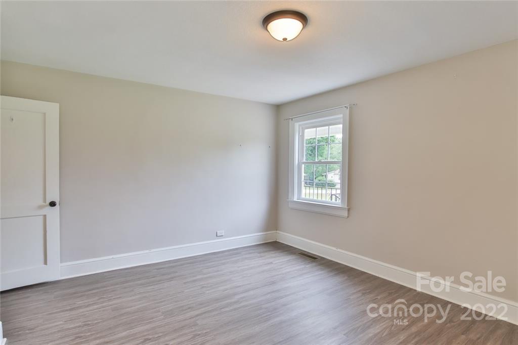 263 McCrary Place Lenoir, NC 28645 - Photo 12 of 40 an empty room with wooden floor and windows