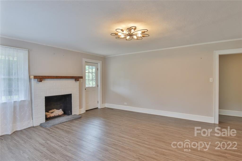 263 McCrary Place Lenoir, NC 28645 - Photo 8 of 40 a view of an empty room with wooden floor and fireplace