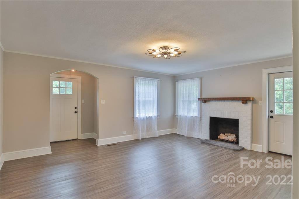 263 McCrary Place Lenoir, NC 28645 - Photo 9 of 40 an empty room with windows fireplace and wooden floor