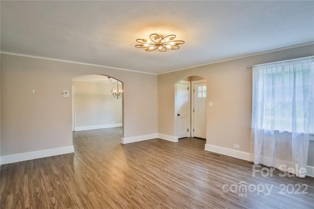 263 McCrary Place Lenoir, NC 28645 - Photo 10 of 40 an empty room with wooden floor chandelier and windows