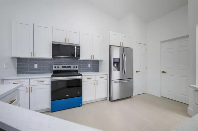 a kitchen with stainless steel appliances a sink stove and refrigerator