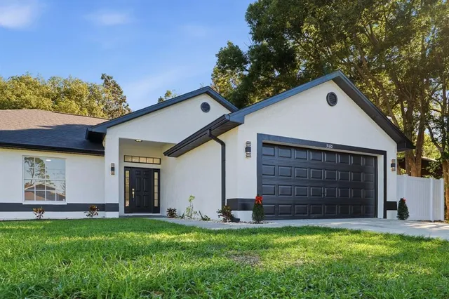 a front view of a house with a yard and garage