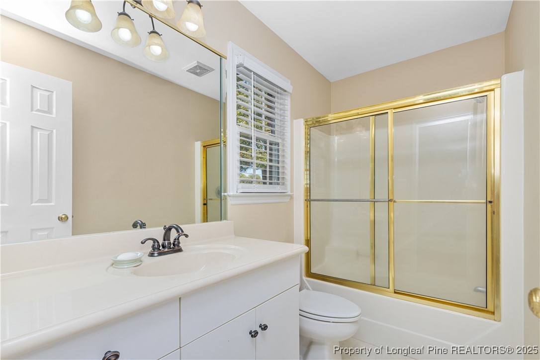 387 3 Bridge Road Dunn, NC 28334 - Photo 37 of 49 a bathroom with a sink a toilet and a large mirror