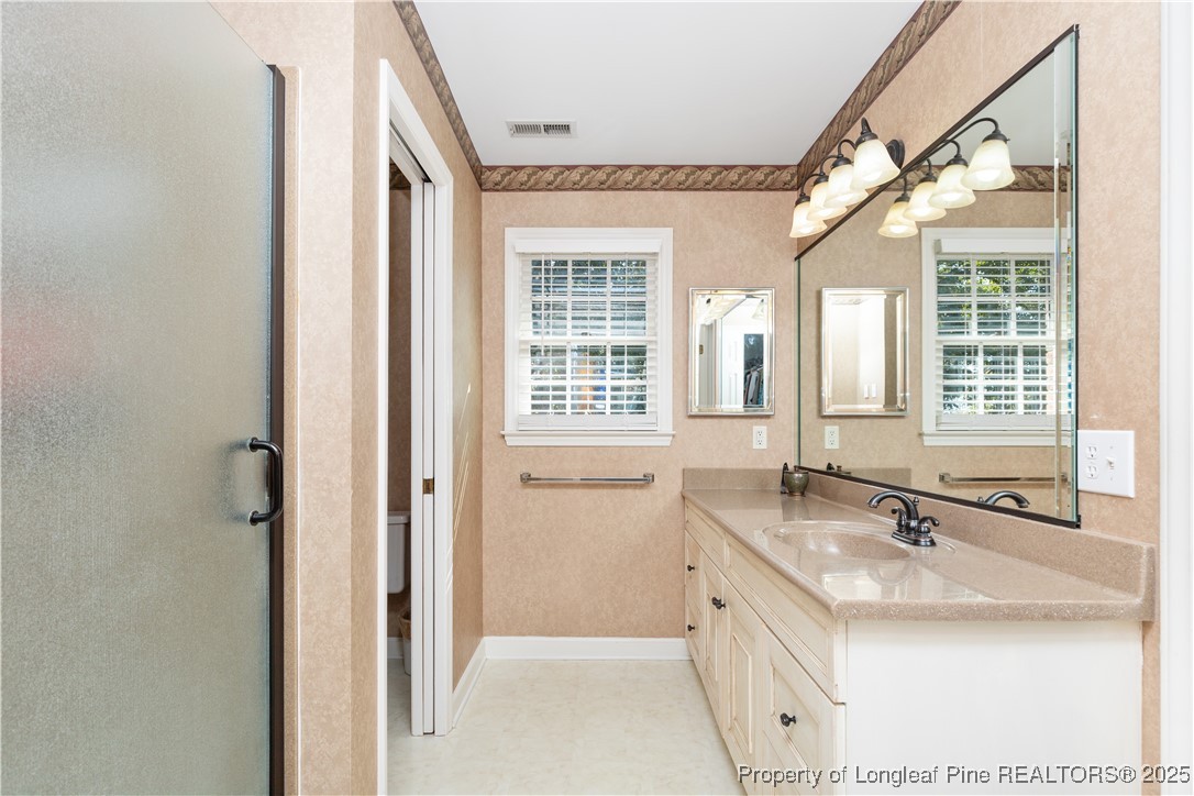 387 3 Bridge Road Dunn, NC 28334 - Photo 44 of 49 a bathroom with a double vanity sink a large mirror and a bathtub