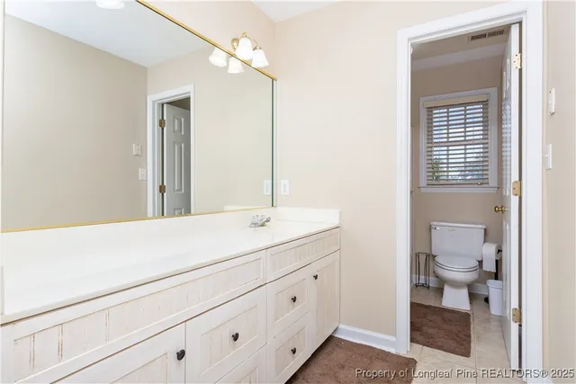 a bathroom with a sink a toilet and a mirror