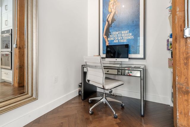 a view of a workspace with furniture and a window