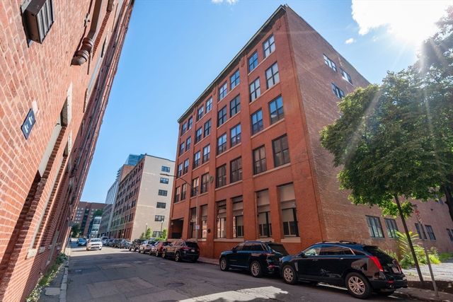 a view of a building and car parked on the street