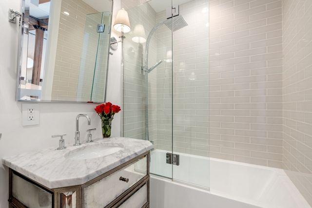 a bathroom with a granite countertop sink a shower and a mirror