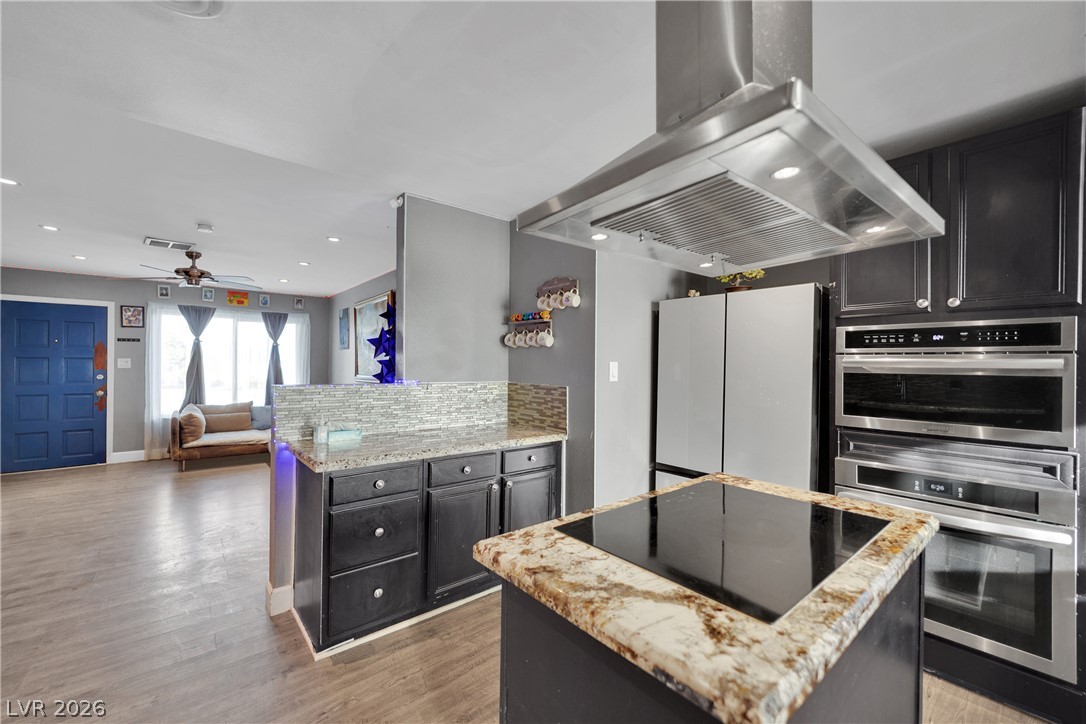 2221 Englestad Street North Las Vegas, NV 89030 - Photo 14 of 32 Culinary delights await in this modern kitchen with granite countertops and sleek built-in appliances.