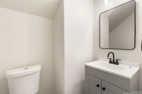 a bathroom with a toilet sink and mirror