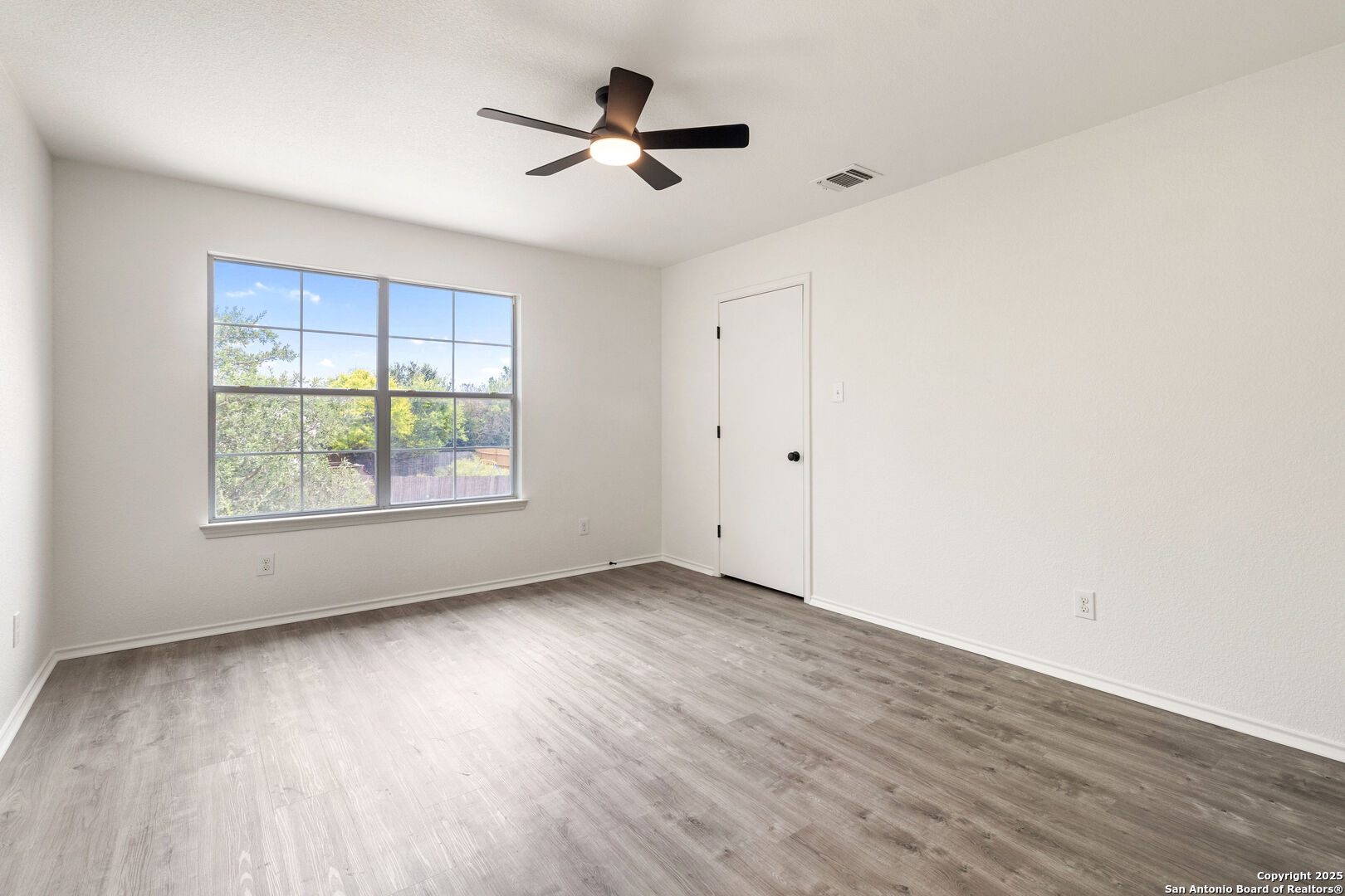 5015 Badland Beacon Converse, TX 78109 - Photo 16 of 23 an empty room with wooden floor fan and windows
