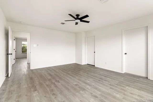 a view of empty room with wooden floor
